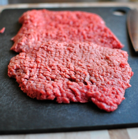 Tenderized grass-fed beef cube steaks on a slate board